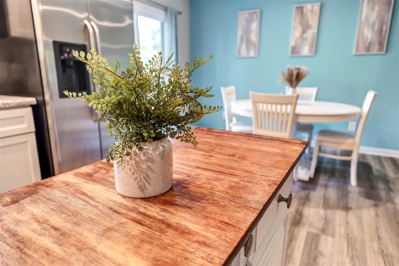 Kitchen island and blue-walled dining area at Bright Wilmington Stay